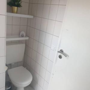 biała łazienka z toaletą i prysznicem w obiekcie Obere Dorfstraße w mieście Wolfsburg