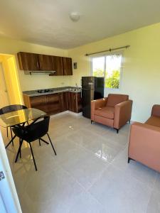 a kitchen with a couch and a chair and a table at Hotel La Playa in Santa Cruz de Barahona