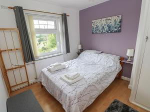 een slaapkamer met een bed met twee handdoeken erop bij 3 Aelybryn in Llanelli