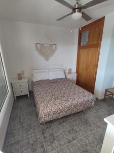 - une chambre avec un lit et un ventilateur de plafond dans l'établissement Apto con vistas Monteluna, à Huelva