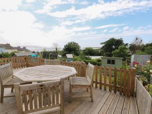 a wooden deck with a wooden table and chairs at 3 Aelybryn in Llanelli