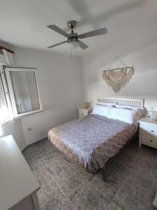 1 dormitorio con 1 cama y ventilador de techo en Apto con vistas Monteluna, en Huelva