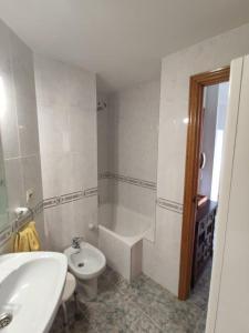 a bathroom with a sink and a toilet and a bath tub at Apto con vistas Monteluna in Huelva