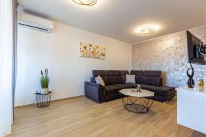 een woonkamer met een bank en een tafel bij Apolon 2BDR apartment with balcony in Zadar