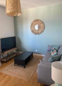 ein Wohnzimmer mit Couch und Tisch in der Unterkunft Le Chinchauvaud - Spacieux T2 - Coup de foudre garanti en face de la gare des Bénédictins in Limoges