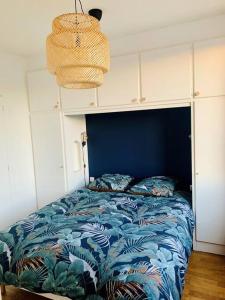 Schlafzimmer mit einem Bett mit blauem Kopfteil in der Unterkunft Le Chinchauvaud - Spacieux T2 - Coup de foudre garanti en face de la gare des Bénédictins in Limoges