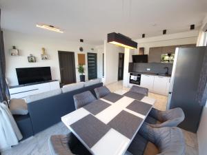 een keuken en een woonkamer met een tafel en stoelen bij Apartments Marebella in Lumbarda