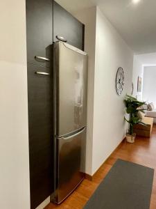a stainless steel refrigerator in the corner of a room at CarreraHouses Canela in Vigo
