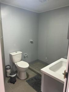 a white bathroom with a toilet and a sink at Klip lagoon apartsments in Oranjestad