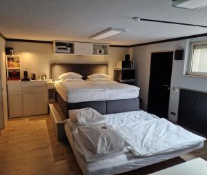 ein kleines Zimmer mit 2 Betten und einer Küche in der Unterkunft GAPSAH-das Apartment mit Kino in Genhülsen