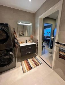 uma casa de banho com um lavatório e uma máquina de lavar roupa em Nytt og flott hus i Haugesund 