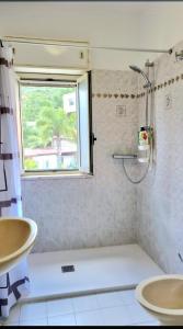 un bagno con doccia, 2 lavandini e finestra di casa didi' a Città di Lipari