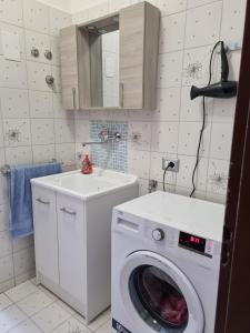 una lavanderia con lavatrice e lavandino di casa didi' a Città di Lipari