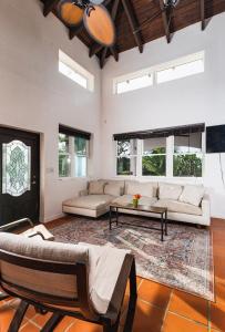 Sala de estar con 2 sofás y mesa en Casa Colibri + Casita - Villa w/ocean views, en Vieques