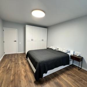 una camera con letto e pavimento in legno di Cozy Apartment Kazlų Rūda a Kazlų Rūda