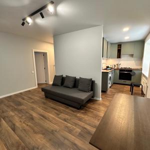a living room with a couch and a kitchen at Cozy Apartment Kazlų Rūda in Kazlų Rūda
