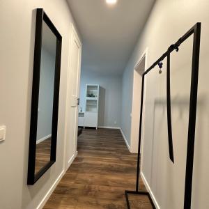 a hallway with a mirror and wooden floors at Cozy Apartment Kazlų Rūda in Kazlų Rūda