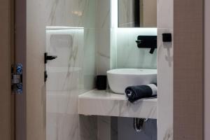 a white bathroom with a sink and a mirror at NERO SEASCAPE SUITES in Fanárion