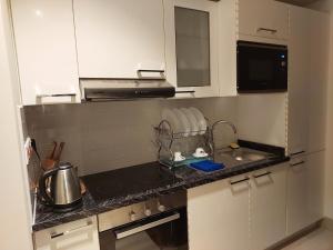 - une cuisine avec un évier et un comptoir dans l'établissement Hawana Salalah - Riviera NEW, à Salalah