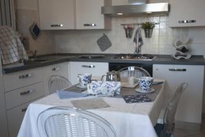 a kitchen with a table with chairs and a sink at Casavacanze Azzurro Mare in Porto SantʼElpidio