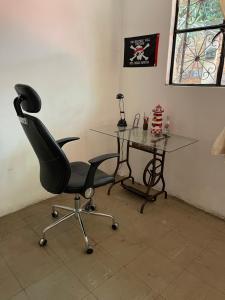 een bureau, een stoel en een glazen tafel bij Casa H236 in Mexico-Stad