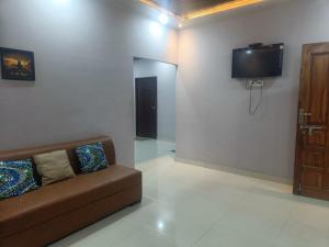 sala de estar con sofá y TV en la pared en Rangili Baag en Varanasi
