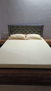 a bed with a black headboard and a white mattress at Rangili Baag in Varanasi