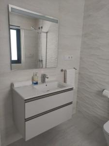 ein weißes Badezimmer mit Waschbecken und Spiegel in der Unterkunft Atlanterra - Mar de Plata in Zahara de los Atunes + 12 Fotos
