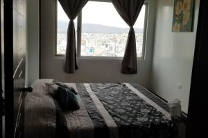Schlafzimmer mit einem Bett und Stadtblick in der Unterkunft Espectacular Casa Vacacional !Sorprendente vista! in Ambato