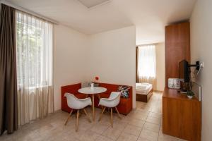 a living room with a table and white chairs at Filaret studios with free parking in Varna City