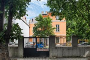a fence in front of a building with a house at Filaret studios with free parking in Varna City