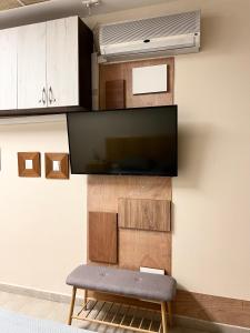 ein Wohnzimmer mit einer Bank und einem TV an der Wand in der Unterkunft Time Traveling Apartment Sofia Mladost District in Sofia