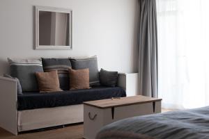 ein Wohnzimmer mit einem Sofa und einem Spiegel in der Unterkunft Noordzee, Hotel & Spa in Cadzand-Bad