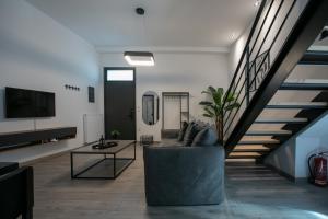 a living room with a couch and a staircase at Casa de Castro - City Apartments in Thessaloniki