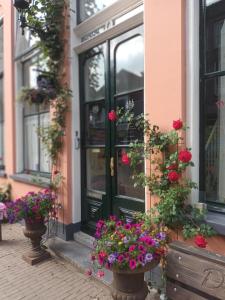 een deur van een gebouw met bloemen ervoor bij De Zevenster "gevestigd aan de winkelstraat" in Kampen