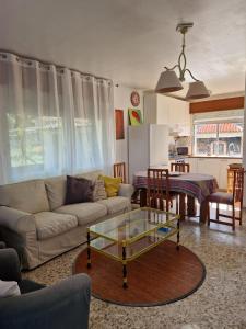 sala de estar con sofá y mesa de cristal en Casa Suricato, en San Vicente do Mar