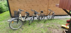 three bikes are parked next to a wall at Leśne Zacisze in Łuka