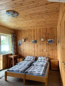 a bedroom with a bed in a wooden room at Willa Emma in Poronin