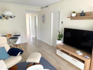 uma sala de estar com uma grande televisão de ecrã plano em Coliseo Albir Beach em Albir