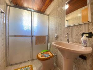 y baño con lavabo y ducha. en Casa aconchegante pertinho de tudo, ótima localização., en Campos do Jordão