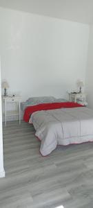 a white bedroom with a bed with a red blanket at Asociación deportiva TAGOROR LOS OLIVITOS in Adeje