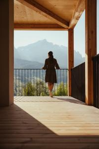 a woman walking on a porch with a view at Hotel Lech Da Sompunt in Badia