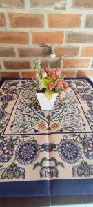 a vase with flowers on a table on a tile floor at Quarto Privado-Suite Aconchego-Miguel Pereira / RJ in Miguel Pereira