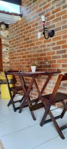 a wooden table in front of a brick wall at Quarto Privado-Suite Aconchego-Miguel Pereira / RJ in Miguel Pereira