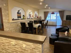 a restaurant with a dining room with tables and chairs at Apartament Darius in Moieciu de Sus