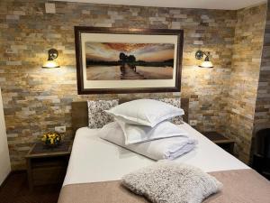 a bedroom with a bed with a picture on the wall at Apartament Darius in Moieciu de Sus