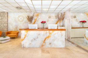 a marble counter in a room with flowers on the wall at Hotel Adria in Malinska