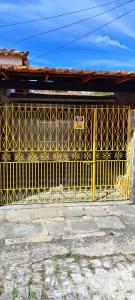 a yellow gate in front of a building at Quarto Privado-Suite Aconchego-Miguel Pereira / RJ in Miguel Pereira