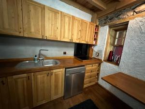 a kitchen with wooden cabinets and a sink at Faralya Villa in Fethiye