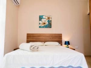 um quarto com uma cama grande com lençóis brancos em Sea views apartment-wifi-sleep 5 em Marsaskala